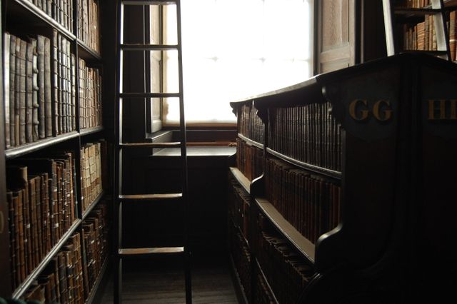 Dimly Lit Antique Library with Ladder and Historical Bookshelves - Download Free Stock Photos Pikwizard.com