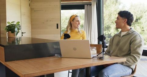Recording cozy home podcast with two hosts at modern kitchen table
