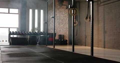 Industrial gym interior with workout equipment featuring gymnastic rings