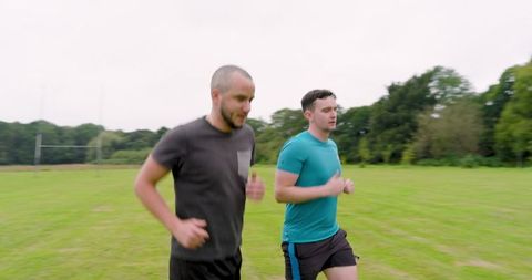 Two Men Enjoying an Outdoor Jog in Green Park for Fitness