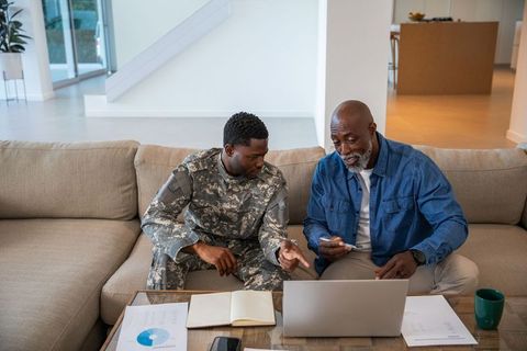 Father and Soldier Son Collaborating at Home on Laptop