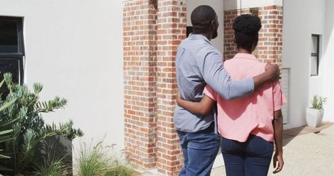Happy Couple Embracing While Viewing New Home Together