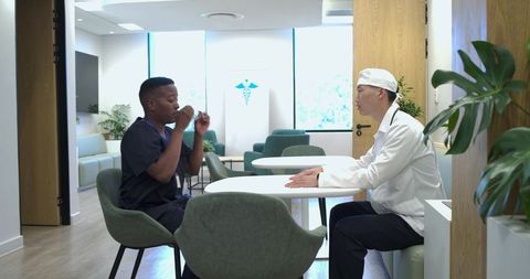 Clinicians discussing patient care in modern clinic breakroom during casual staff break