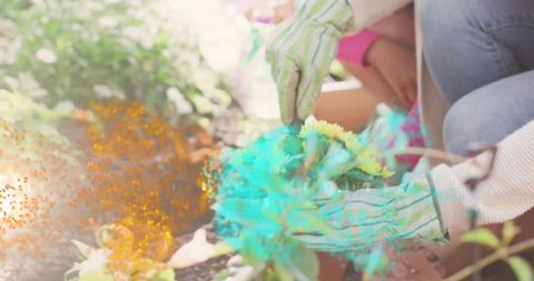 Mother and Daughter Planting Yellow Flowers Together Outdoors