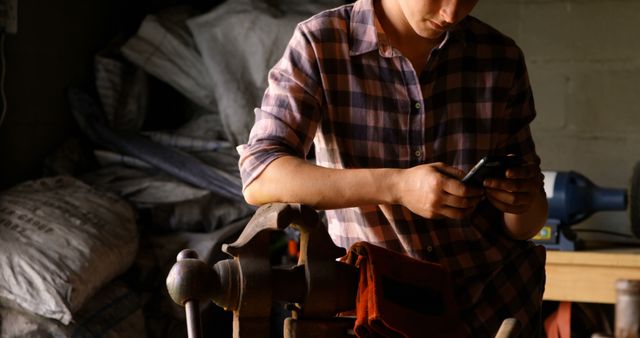 Craftsperson in Workshop Using Smartphone for Project - Download Free Stock Images Pikwizard.com