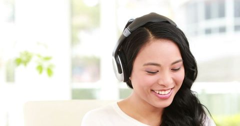 Young Woman Enjoying Music While Working in Office