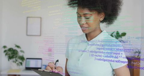Woman developer reviewing code on clipboard in home office with laptop and code overlay