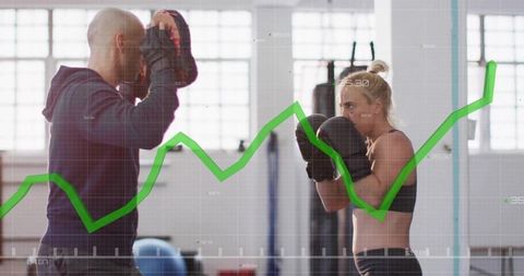 Female Boxer Intense Training with Coach Demonstrating Progress Graph