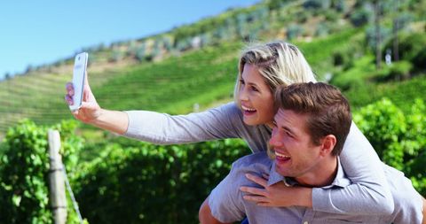 Joyful Couple Taking Selfie in Vibrant Vineyard