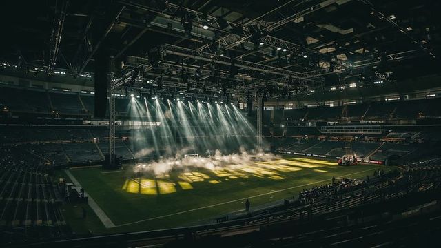 Fog and Illuminated Grass Patch Inside Large Stadium