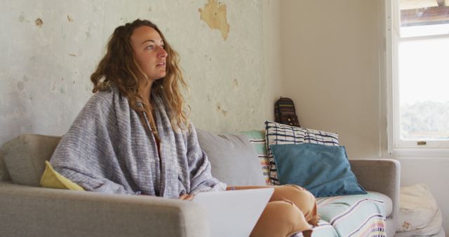 Woman Relaxing on Couch with Blanket in Cozy Living Room - Download Free Stock Images Pikwizard.com