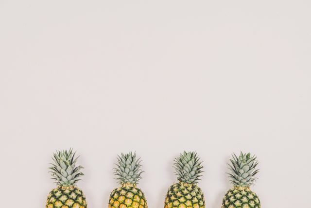 Four Pineapples in a Row Against White Background - Download Free Stock Photos Pikwizard.com