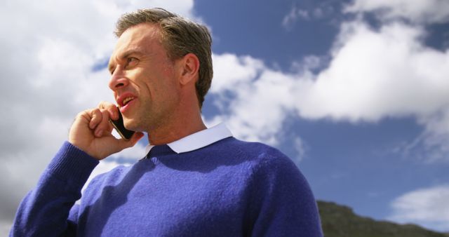 Businessman Talking on Smartphone Outdoors on a Cloudy Day - Download Free Stock Images Pikwizard.com