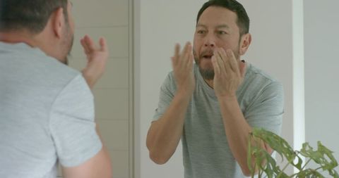 Senior man practicing self-care skincare routine at vanity