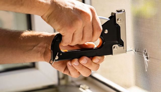 Securing torn window screen with manual staple gun diy mesh repair and sash maintenance