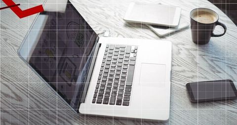 Silver laptop sitting open on round table with tablet phone coffee for remote work