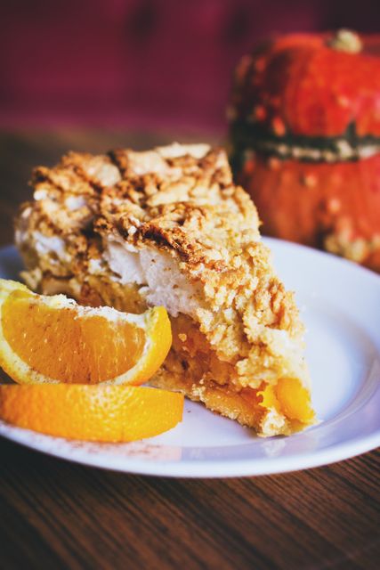 Close-up of Pumpkin Pie Slice with Fresh Orange Garnish on Wooden Table - Download Free Stock Photos Pikwizard.com
