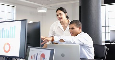 Multiracial Business Team Analyzing Data on Office Computers