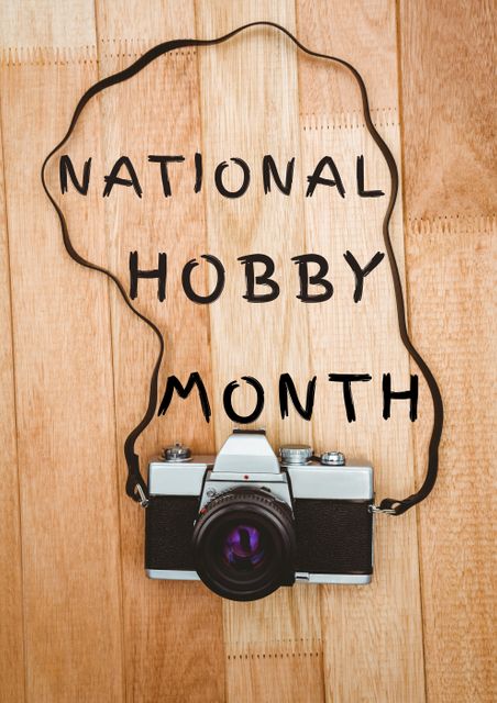 Overhead view of national hobby month text inside vintage camera strap on wooden table. digital composite of symbol, skill and creativity.