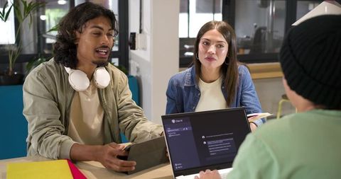 Young African coworkers collaborating on digital project in modern coworking space