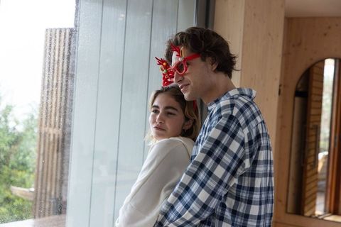 Couple Embracing in Cozy Cabin with Red Antler Glasses