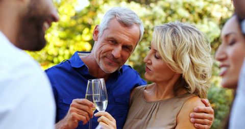 Middle-Aged Couple Enjoying Celebration with Friends Outdoors