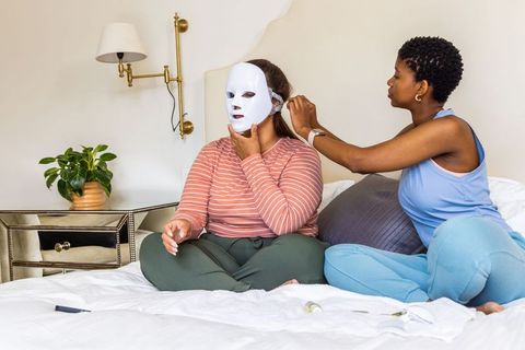 African american women using led facial mask for at-home skincare and self-care