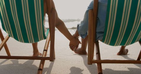 African american couple relaxing holding hands on beach