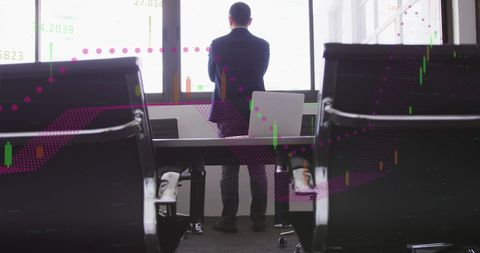 Businessman Analyzing Financial Charts in Office Setting