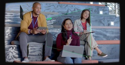 Team collaborating with laptop, tablet and ar overlay while reviewing presentation on tiered seating