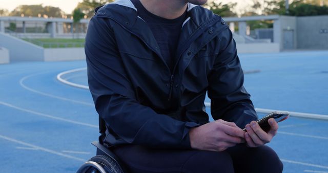 Wheelchair Athlete on Track Using Smartphone During Training - Download Free Stock Images Pikwizard.com