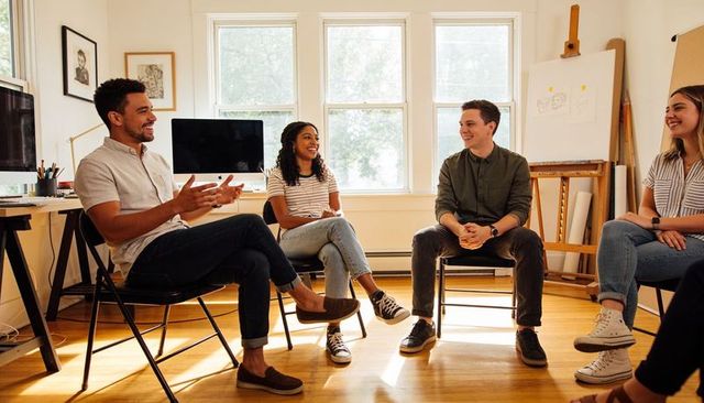 Sunlit creative team meeting in home studio collaborating on ideas and casual discussion