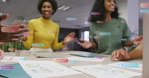 Diverse team collaborating around table with data charts and ar tags for analytics