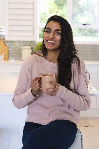 Indian Woman Enjoying Tea at Modern Kitchen