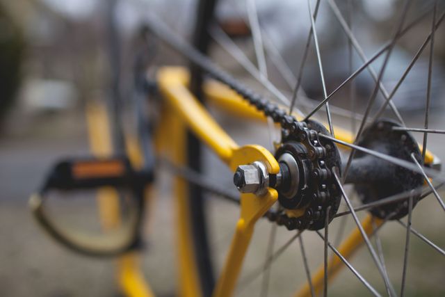 Detailed view of yellow bicycle gear and chain, perfect for illustrating cycling-related content, mechanical details, or sports equipment. Ideal for use in articles, blogs, or promotional materials focusing on biking, outdoor activities, or mechanical engineering.