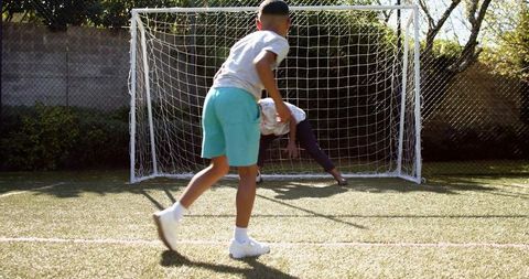 Grandmother and Grandson Playing Soccer in Backyard Game