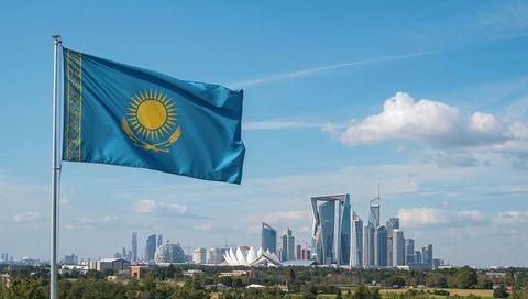 Kazakhstan Flag Waving Over Astana Skyline With Futuristic Skyscrapers and Blue Sky