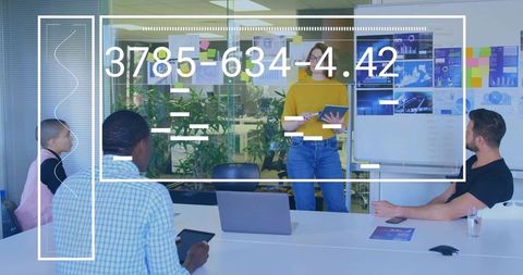 Presenting team collaborating in modern boardroom showing data visualizations on tablets