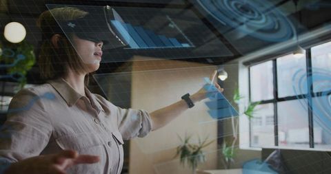 Asian woman wearing mr headset interacting with ar dashboards in office workspace