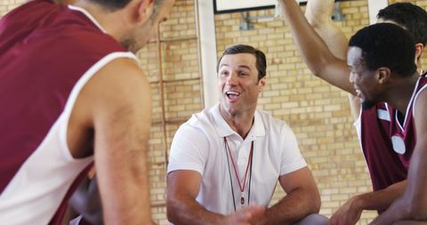 Coach and Team Celebrating with Handstack in Basketball Court