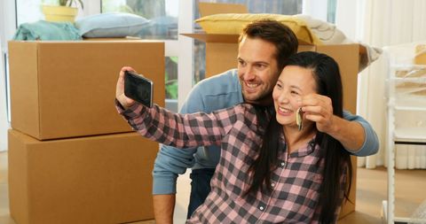 Couple Celebrating New Home with Selfie Among Moving Boxes - Download Free Stock Images Pikwizard.com