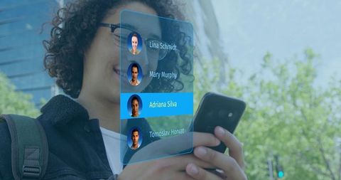 Young man holding phone viewing holographic ar contacts interface on urban sidewalk