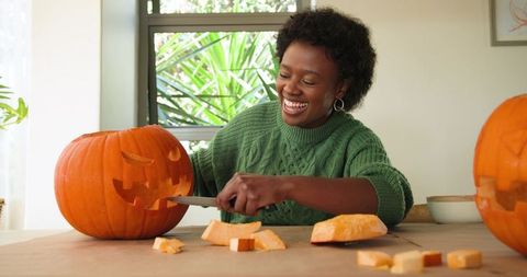 Joyful Woman Carving Pumpkin for Halloween Decor