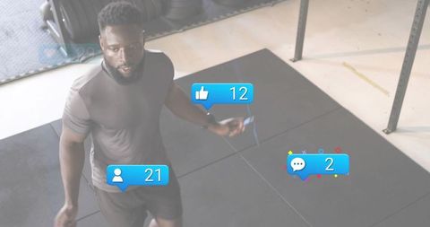 Fit man jumping rope in gym with social media likes followers and comment notifications