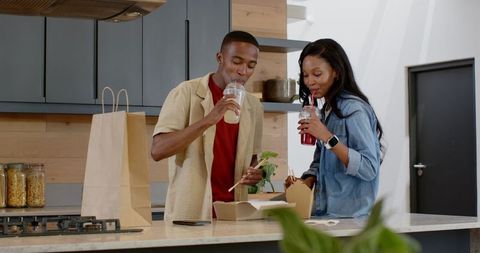 Friends Enjoying Takeout Lunch in Modern Kitchen