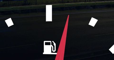 Fuel gauge graphic overlay with red needle on dark highway night roadside