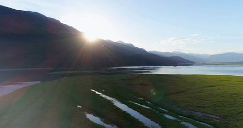 Sunrise Over Mountain Ridge Illuminates Serene Valley and Lake