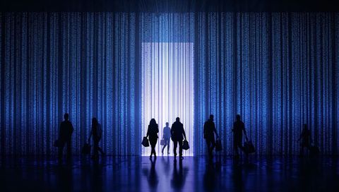 Silhouetted travelers walking toward luminous portal in blue digital corridor with data streams