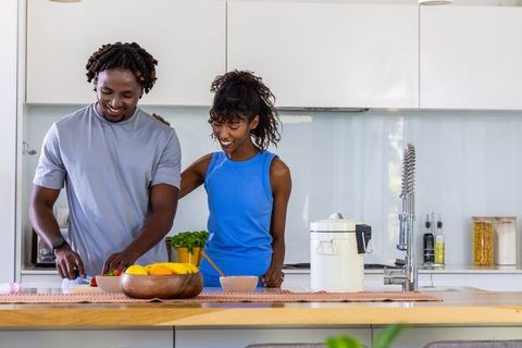 African american couple preparing healthy meal in modern kitchen, chopping vegetables
