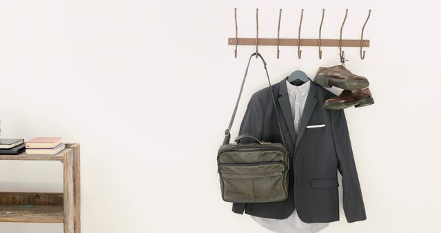 A tidy room with a business suit and accessories on a coat rack implies a professional setting. - Download Free Stock Photos Pikwizard.com